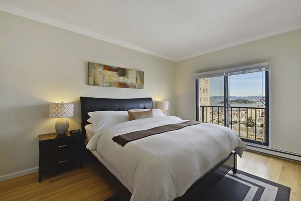Cozy bedroom with city views at Nob Hill Tower Apartments