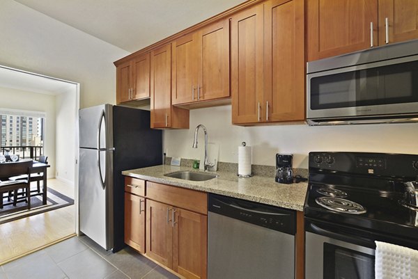 Modern kitchen with stainless steel appliances and granite countertops at Nob Hill Tower Apartments