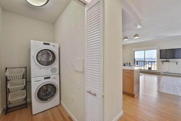 Modern laundry room with high-efficiency washers and dryers at Nob Hill Tower Apartments