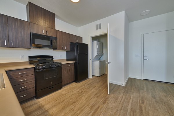Open-concept living room with modern decor and large windows in Alpine Vista Apartments