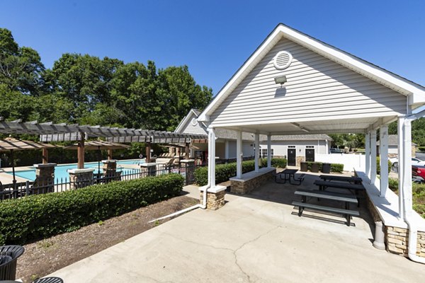 Patio with modern seating and lush greenery at Avana Avebury Apartments
