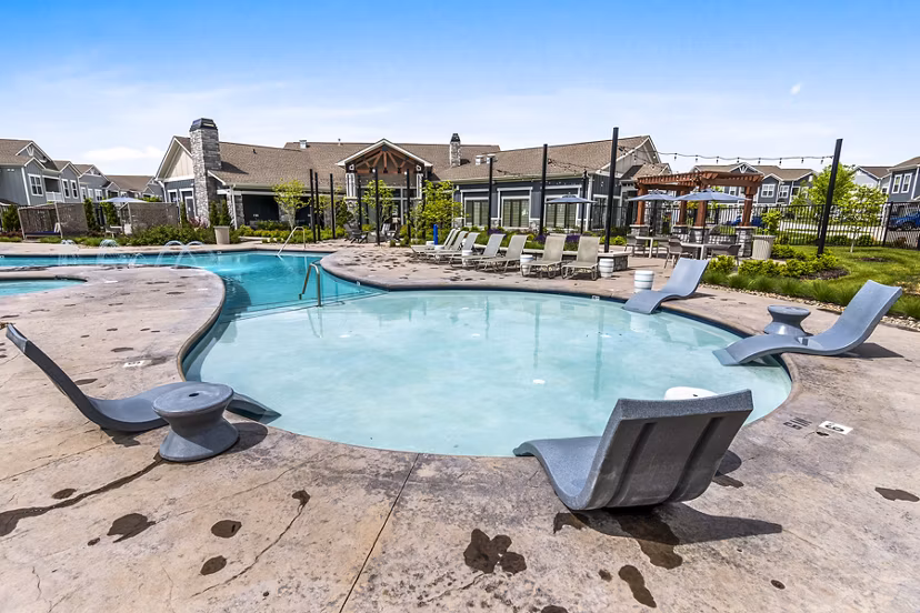 Luxurious pool at The Landing at Tiffany Springs Apartments with modern design and ample seating for relaxation