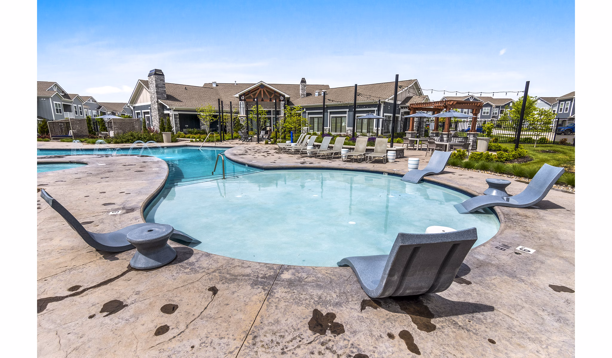 Luxurious pool at The Landing at Tiffany Springs Apartments with modern design and ample seating for relaxation