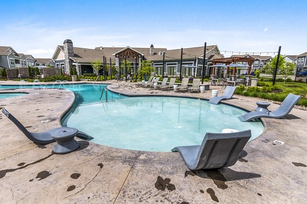 Luxurious pool at The Landing at Tiffany Springs Apartments with modern design and ample seating for relaxation