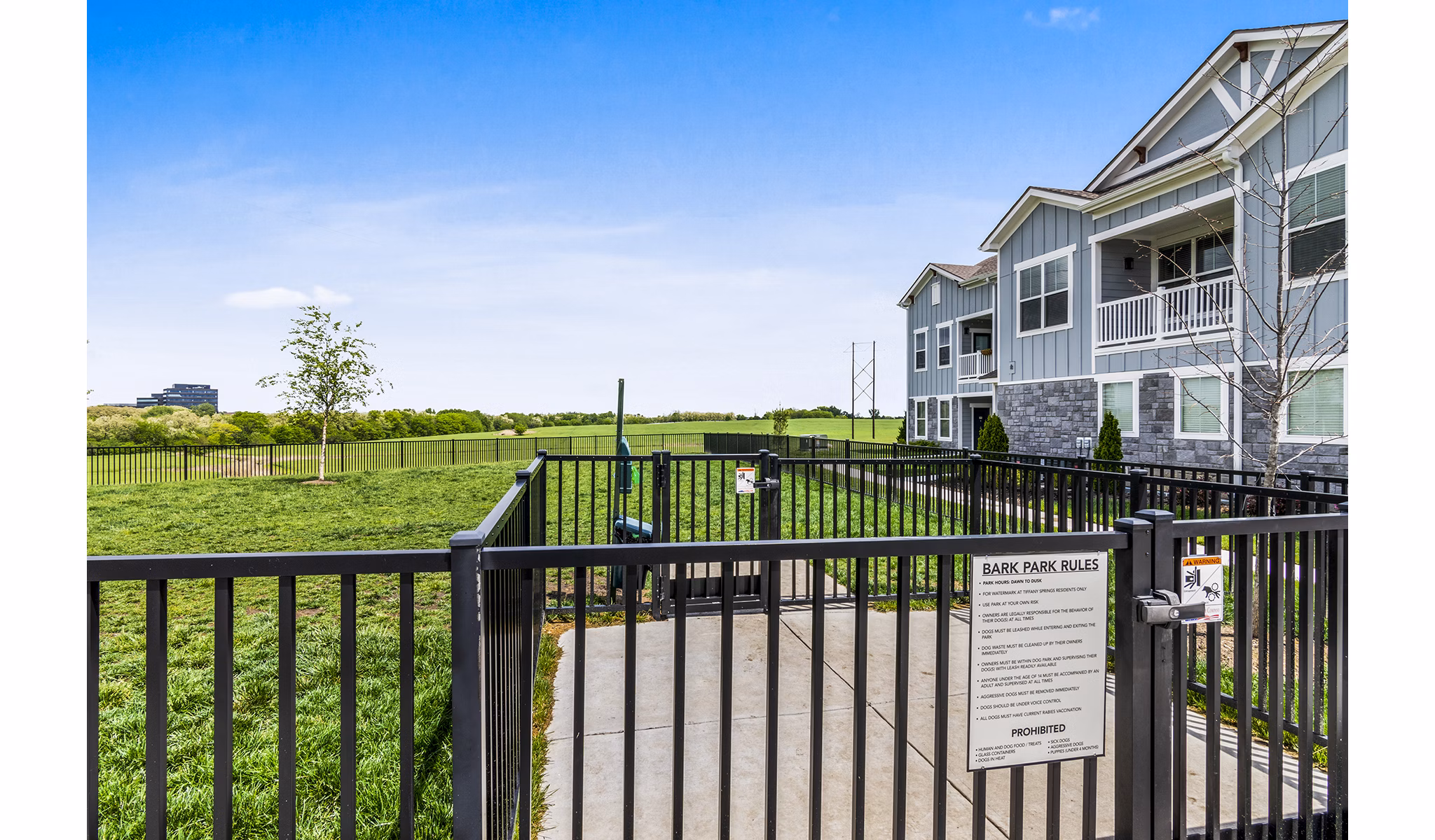 Dog park with green space at The Landing at Tiffany Springs Apartments, perfect for pet-friendly luxury living