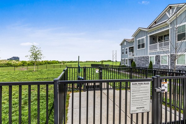 Dog park with green space at The Landing at Tiffany Springs Apartments, perfect for pet-friendly luxury living