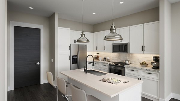 Modern kitchen featuring white cabinets and stainless steel appliances in luxury apartments