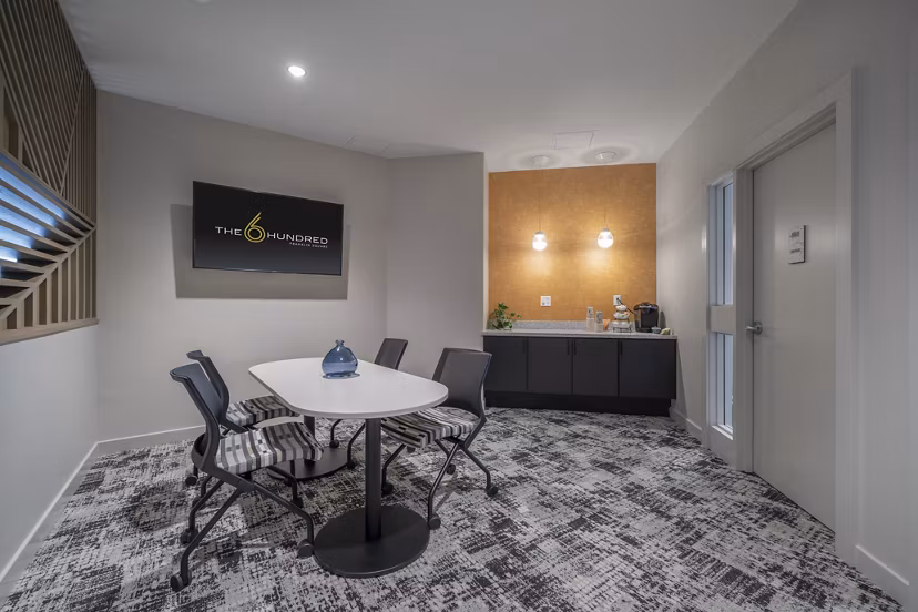 Meeting room with modern furnishings and large windows at The 6Hundred Apartments