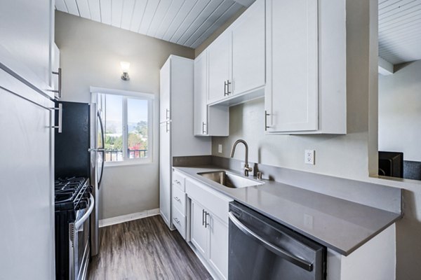 Modern kitchen with stainless steel appliances and granite countertops at Breakpointe Coronado Apartments, luxury living in a coastal setting