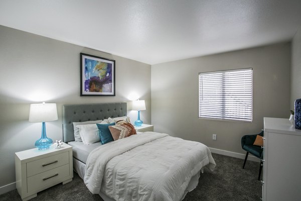 Modern bedroom with plush bedding and natural light at Villas at 6300 Apartments