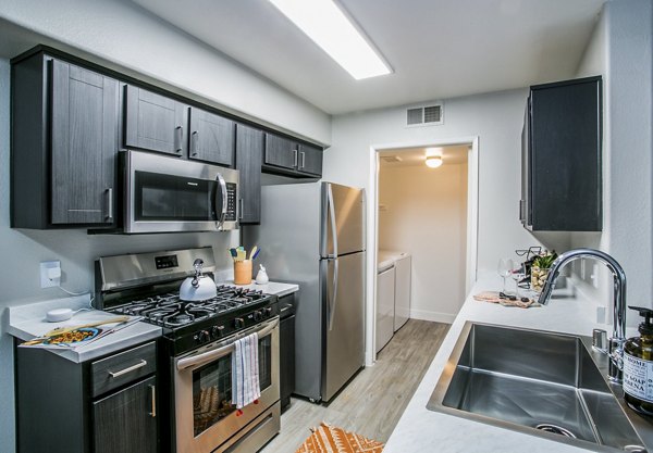 Modern kitchen with stainless steel appliances at Villas at 6300 Apartments