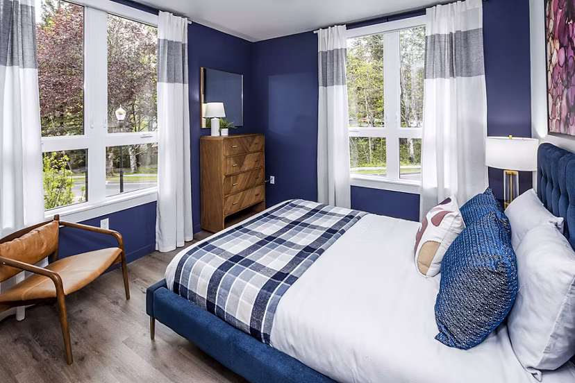 Bedroom with modern decor at Mercato Grove Apartments, featuring large windows and stylish furnishings ideal for luxury living