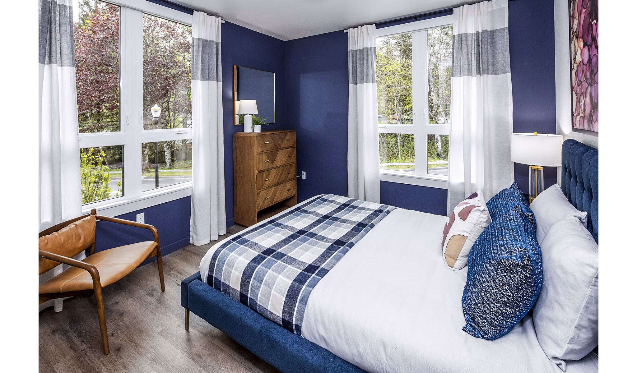 Bedroom with modern decor at Mercato Grove Apartments, featuring large windows and stylish furnishings ideal for luxury living