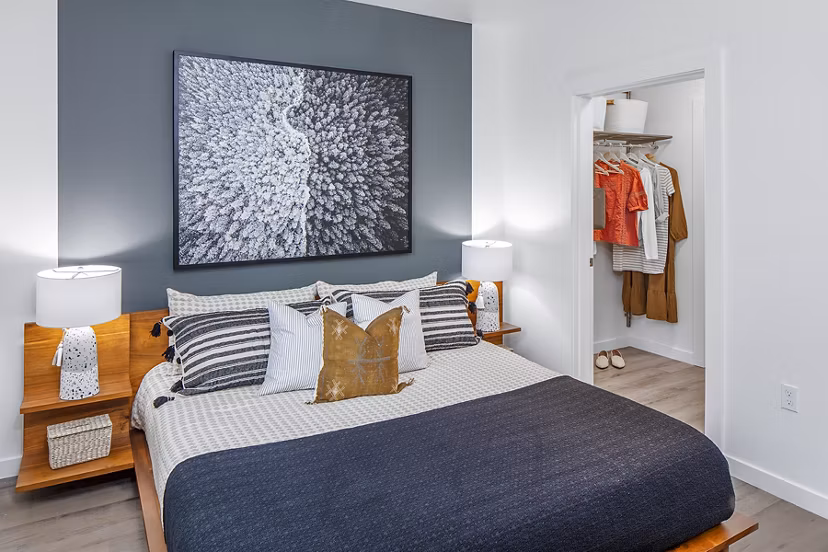 Modern bedroom featuring elegant decor and large windows at Mercato Grove Apartments