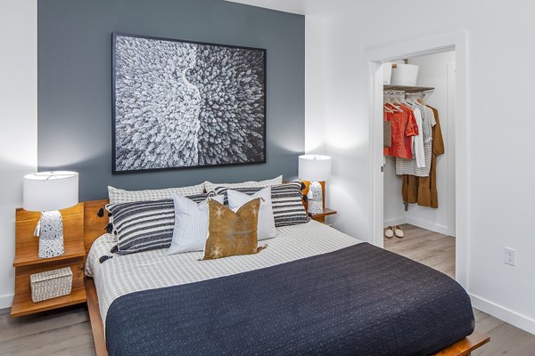 Modern bedroom featuring elegant decor and large windows at Mercato Grove Apartments