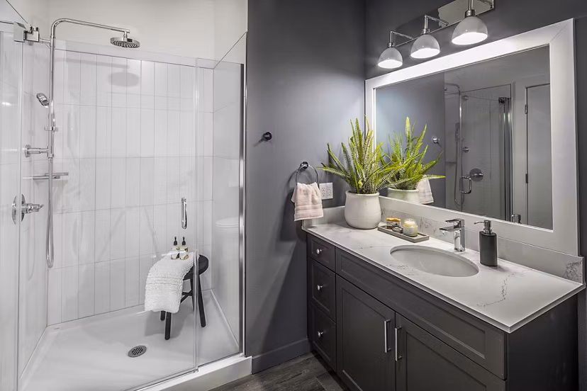 Modern bathroom with sleek fixtures and large mirror at Mercato Grove Apartments