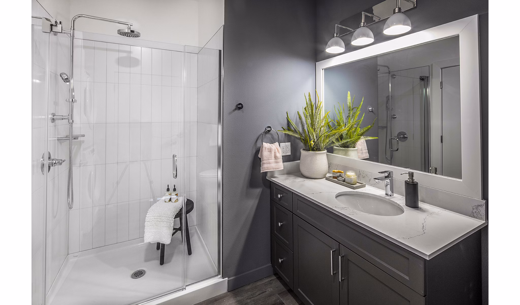Modern bathroom with sleek fixtures and large mirror at Mercato Grove Apartments