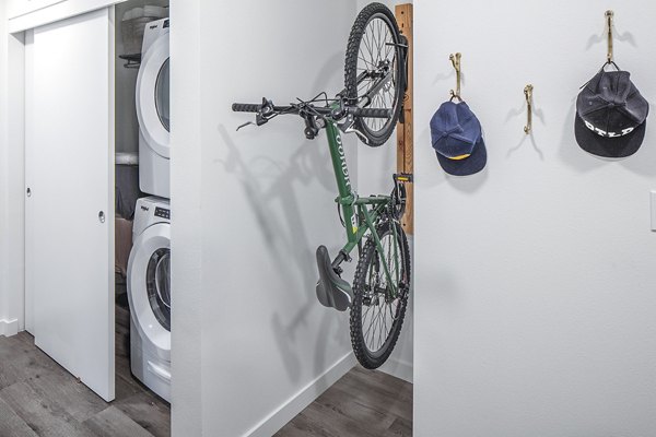 Laundry room with modern appliances and bike storage at Mercato Grove Apartments in urban setting