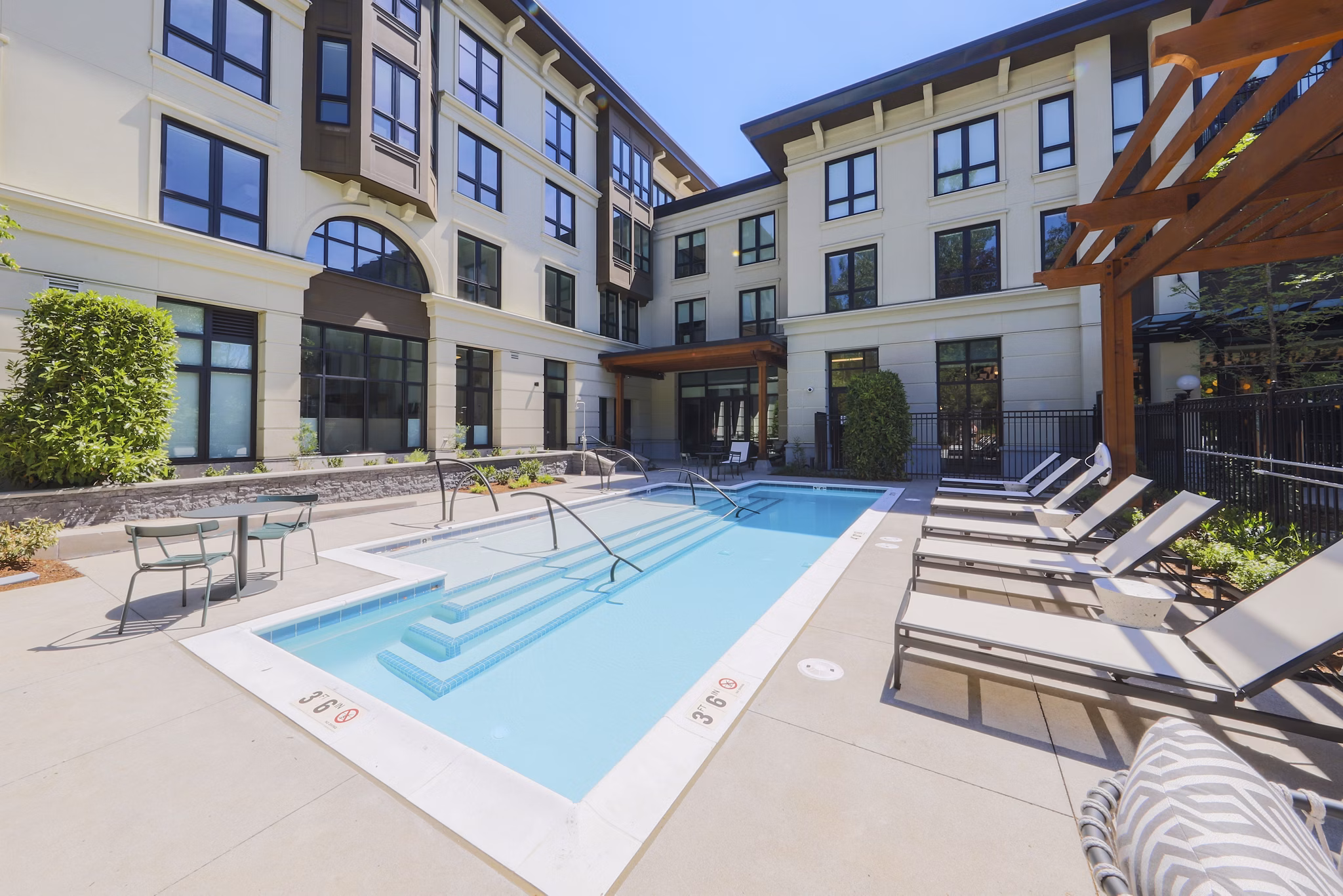 Modern outdoor pool with sun loungers at Mercato Grove Apartments for luxury living