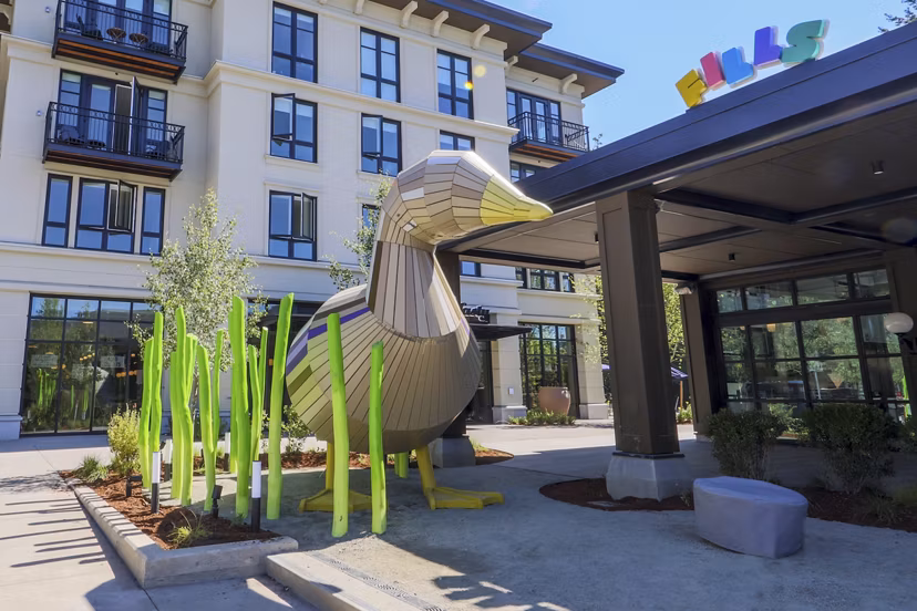 Courtyard featuring lush landscaping and outdoor seating at Mercato Grove Apartments in Italy, Oregon