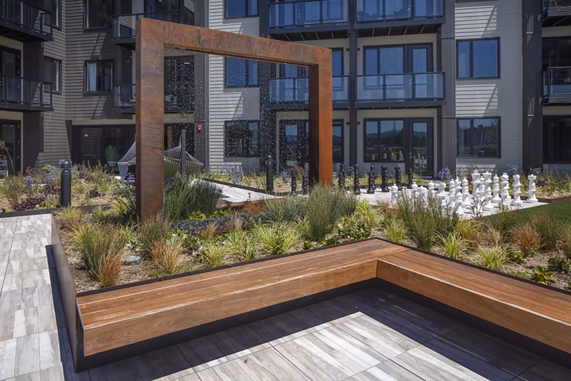 Serene courtyard featuring lush greenery and seating areas at Aria Apartments