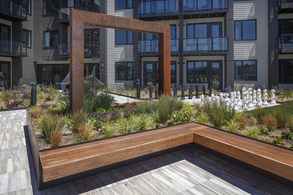 Serene courtyard featuring lush greenery and seating areas at Aria Apartments