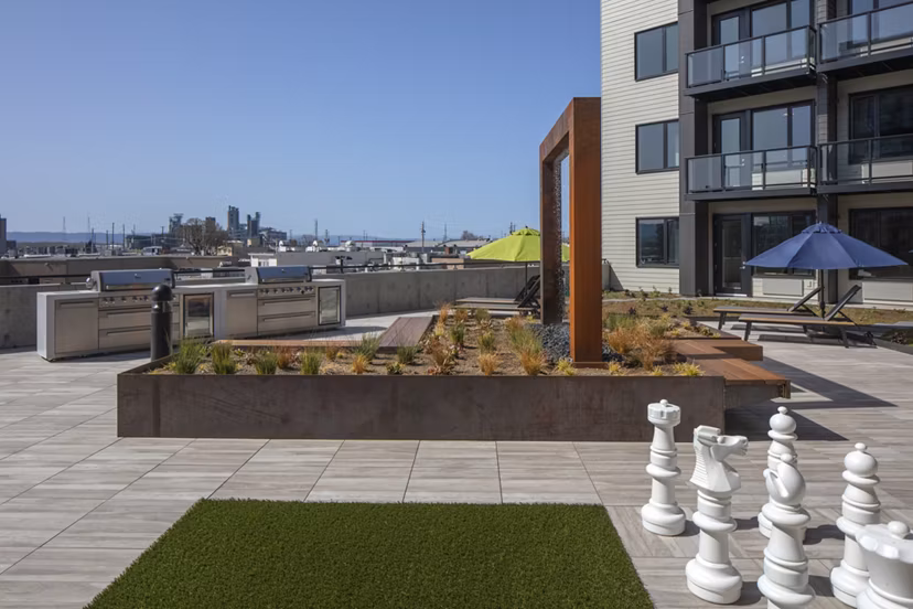 Outdoor grill area at Aria Apartments featuring modern barbecue stations and seating