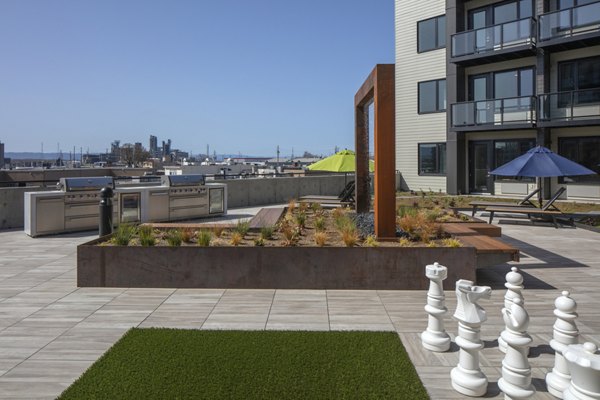 Outdoor grill area at Aria Apartments featuring modern barbecue stations and seating