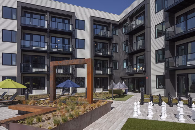 Chic courtyard with manicured greenery at Aria Apartments, offering luxurious outdoor space for residents to relax and socialize