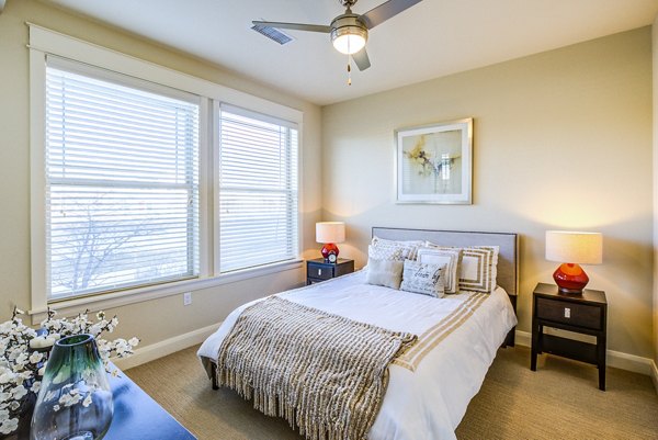 Cozy bedroom with modern furnishings in Everleigh Central Park Apartments