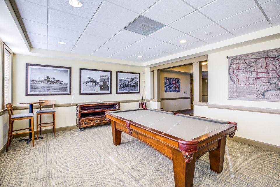 Clubhouse game room with billiards and lounge seating at Everleigh Central Park Apartments