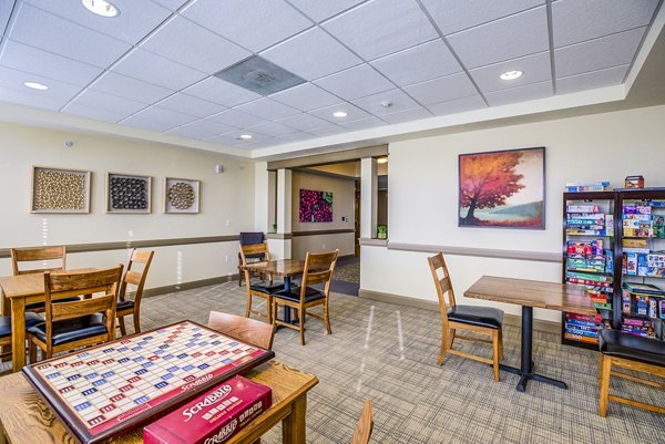 Clubhouse game room with billiards and lounge seating at Everleigh Central Park Apartments