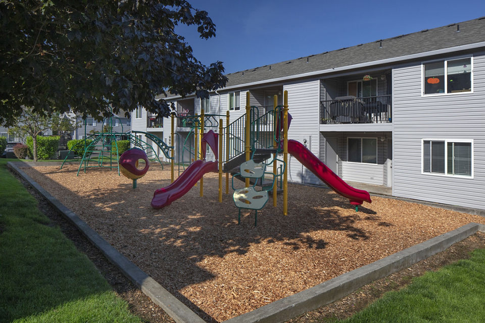 Playground with colorful slides and climbing structures at Avana Evergreen Apartments for family-friendly outdoor fun