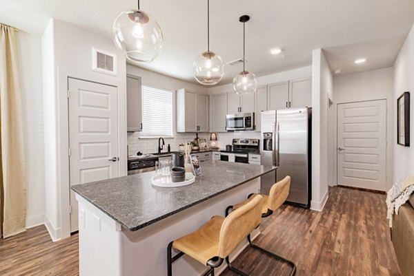 Modern kitchen with stainless steel appliances at Elan Keller Ranch Apartments, featuring sleek countertops and open shelving