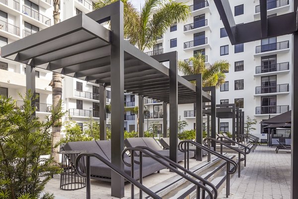Spacious pool patio with sun loungers at Biscayne 112 Apartments, offering luxury outdoor relaxation