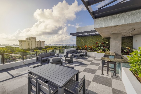 Biscayne 112 Apartments: Inviting patio area with modern seating and lush greenery