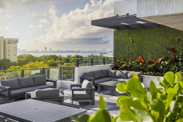 Biscayne 112 Apartments: Stylish patio with modern furniture and lush greenery