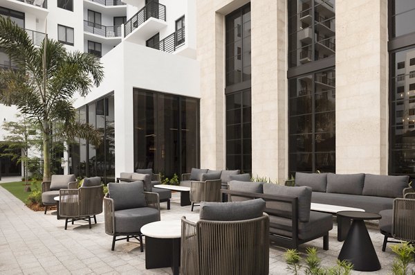 Chic outdoor patio with modern furnishings at Biscayne 112 Apartments in Miami, ideal for relaxation and socializing