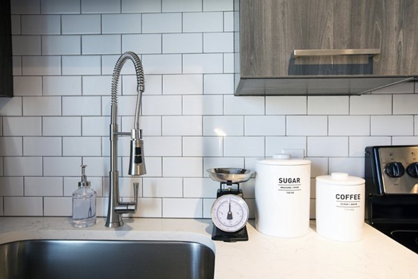 Modern kitchen featuring stainless steel appliances and marble countertops in The Dillon apartments by Kane Residential