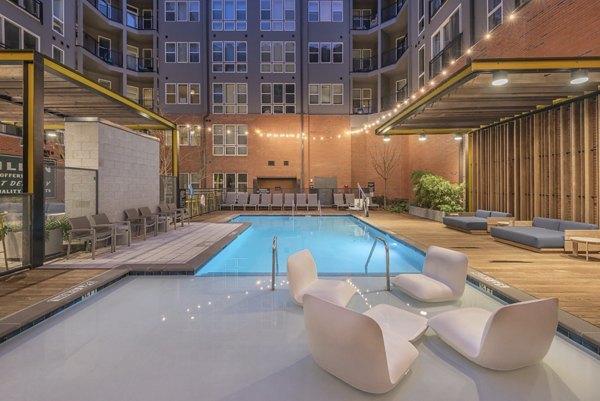 The Dillon Apartments: Outdoor pool area with lounge chairs and city views