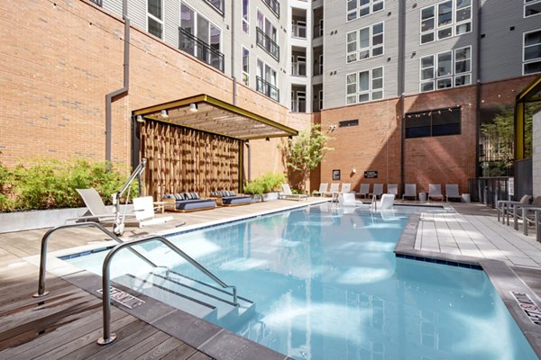 Inviting outdoor pool with lounge seating at The Dillon Apartments, offering luxury relaxation in a vibrant community setting