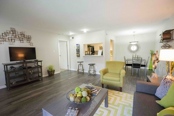 Living room with contemporary decor and large windows in 3 Corners East Apartments