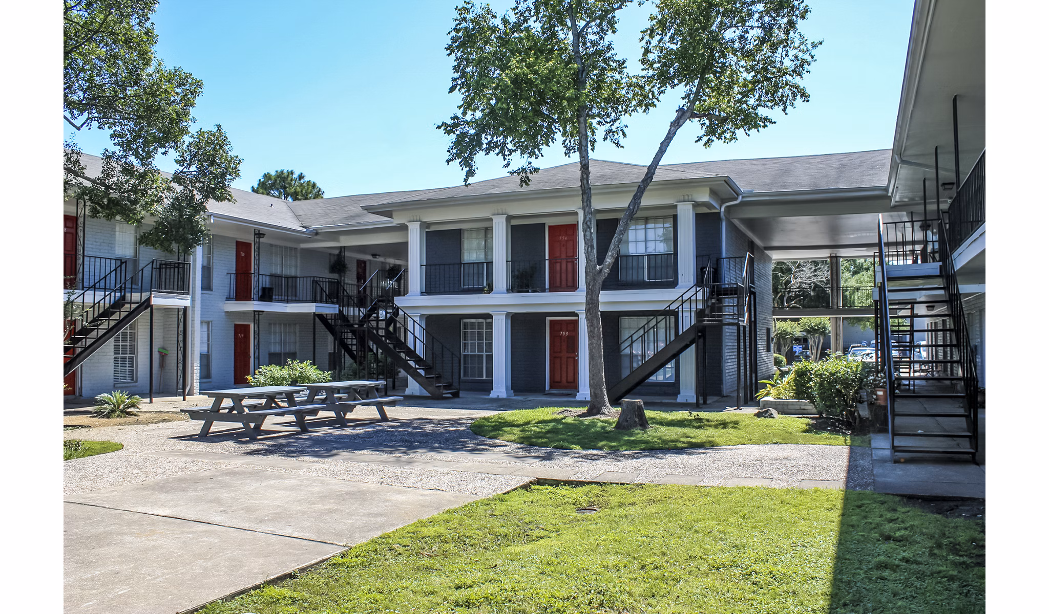 Courtyard featuring lush landscaping and seating areas at 3 Corners West Apartments