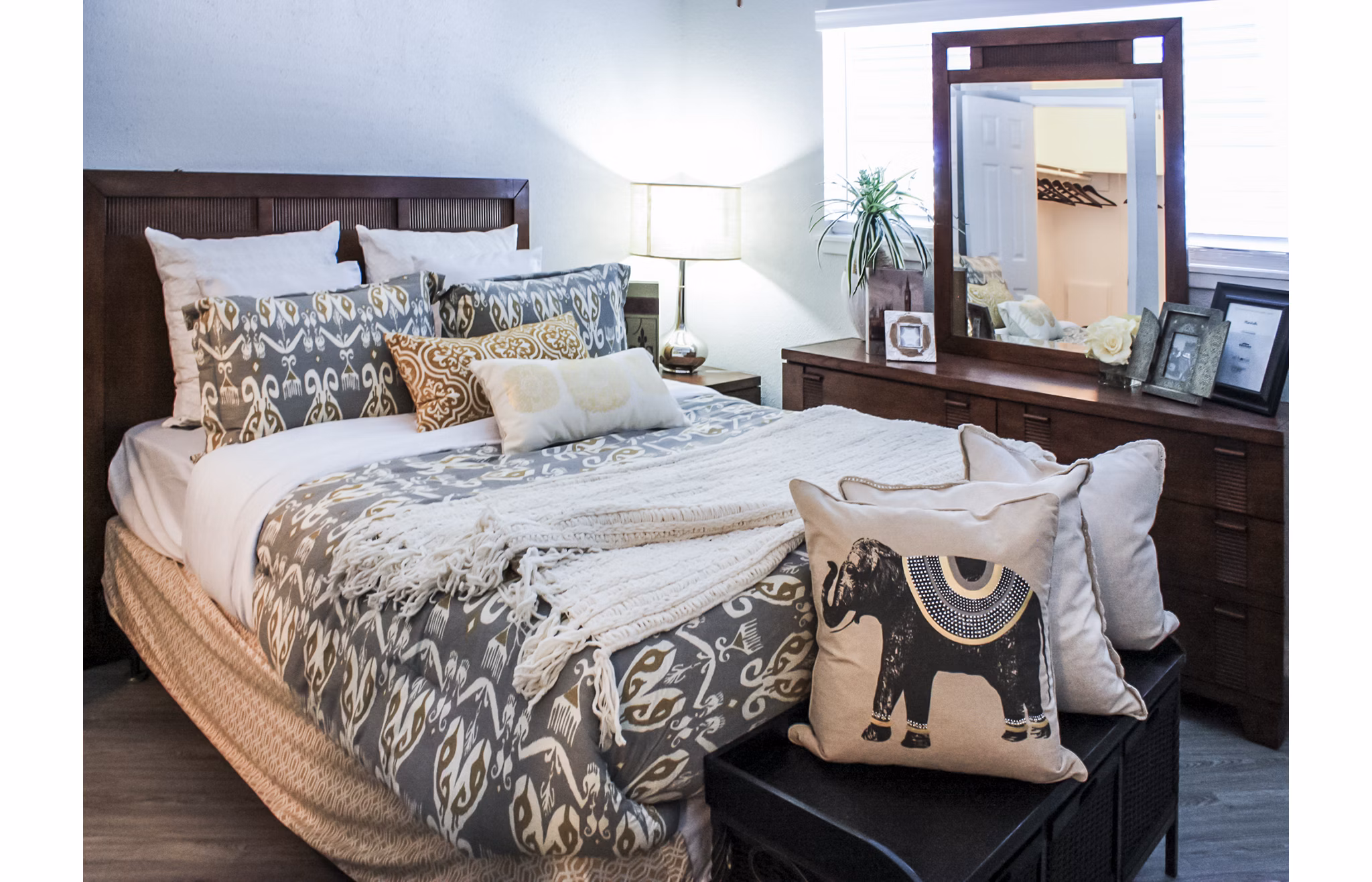 Elegant bedroom with modern decor at 3 Corners West Apartments, featuring cozy bedding and ample natural light
