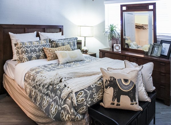 Elegant bedroom with modern decor at 3 Corners West Apartments, featuring cozy bedding and ample natural light