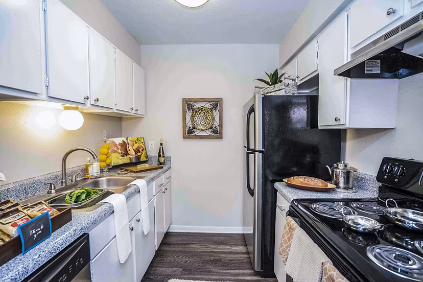 Modern kitchen with granite countertops and stainless steel appliances at 3 Corners West Apartments