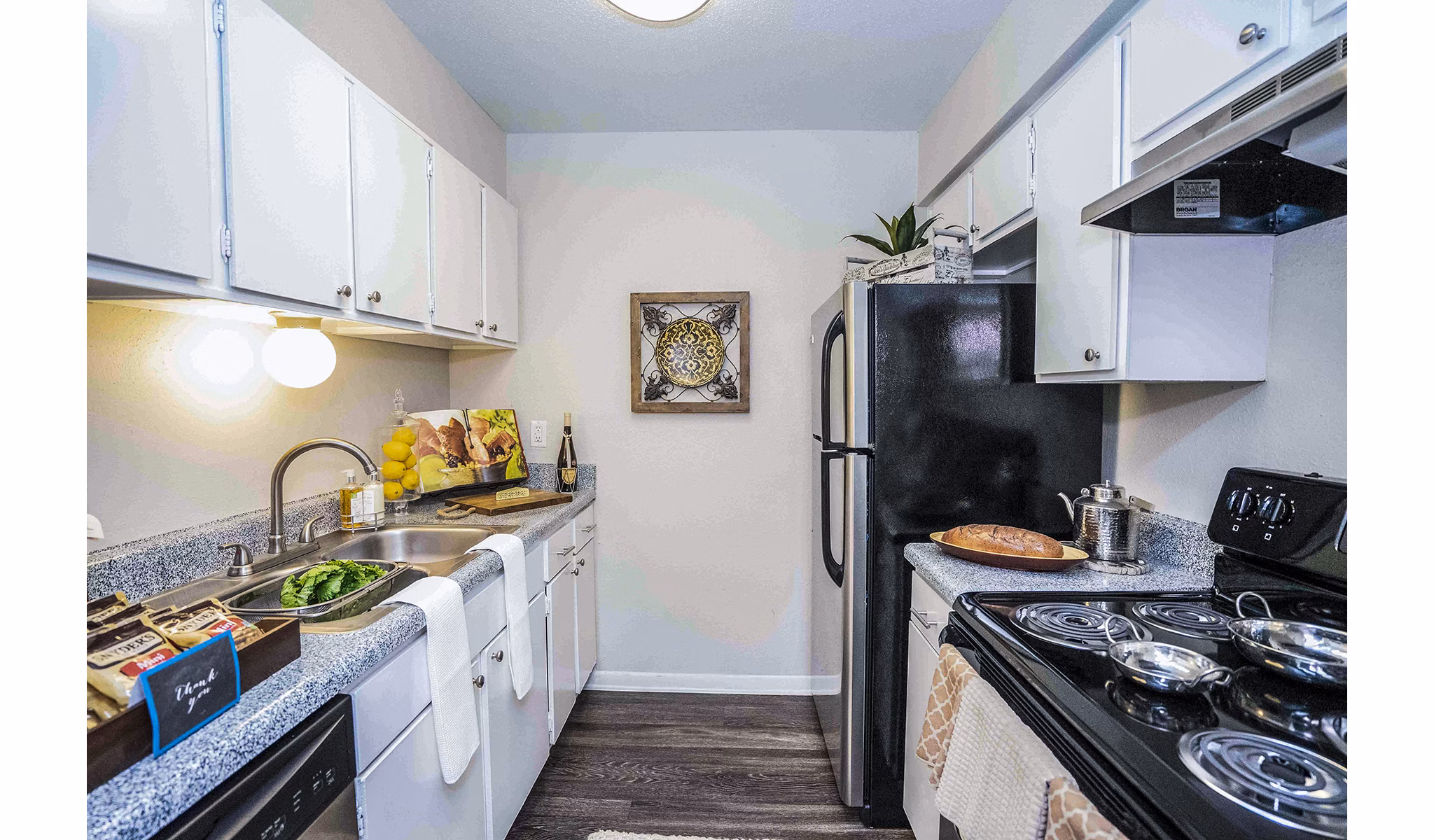 Modern kitchen with granite countertops and stainless steel appliances at 3 Corners West Apartments