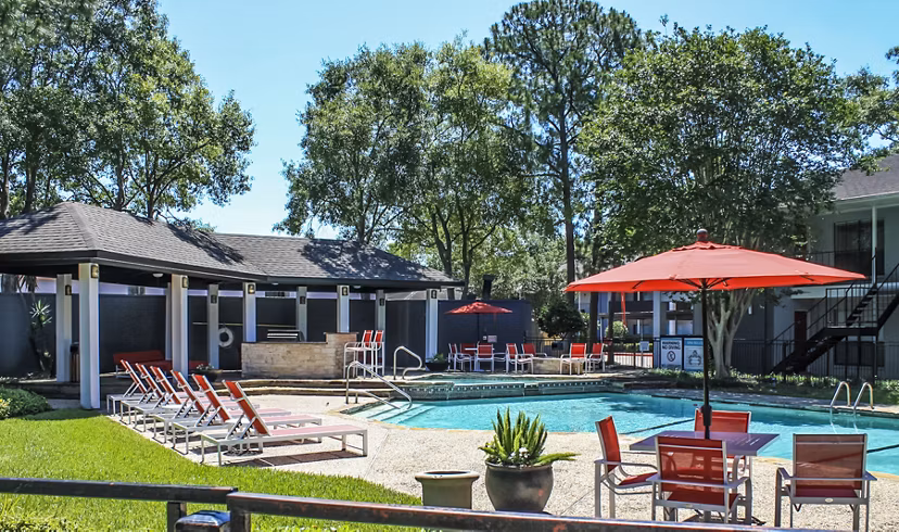 Pool with modern lounge chairs at 3 Corners West Apartments, a luxury residential community