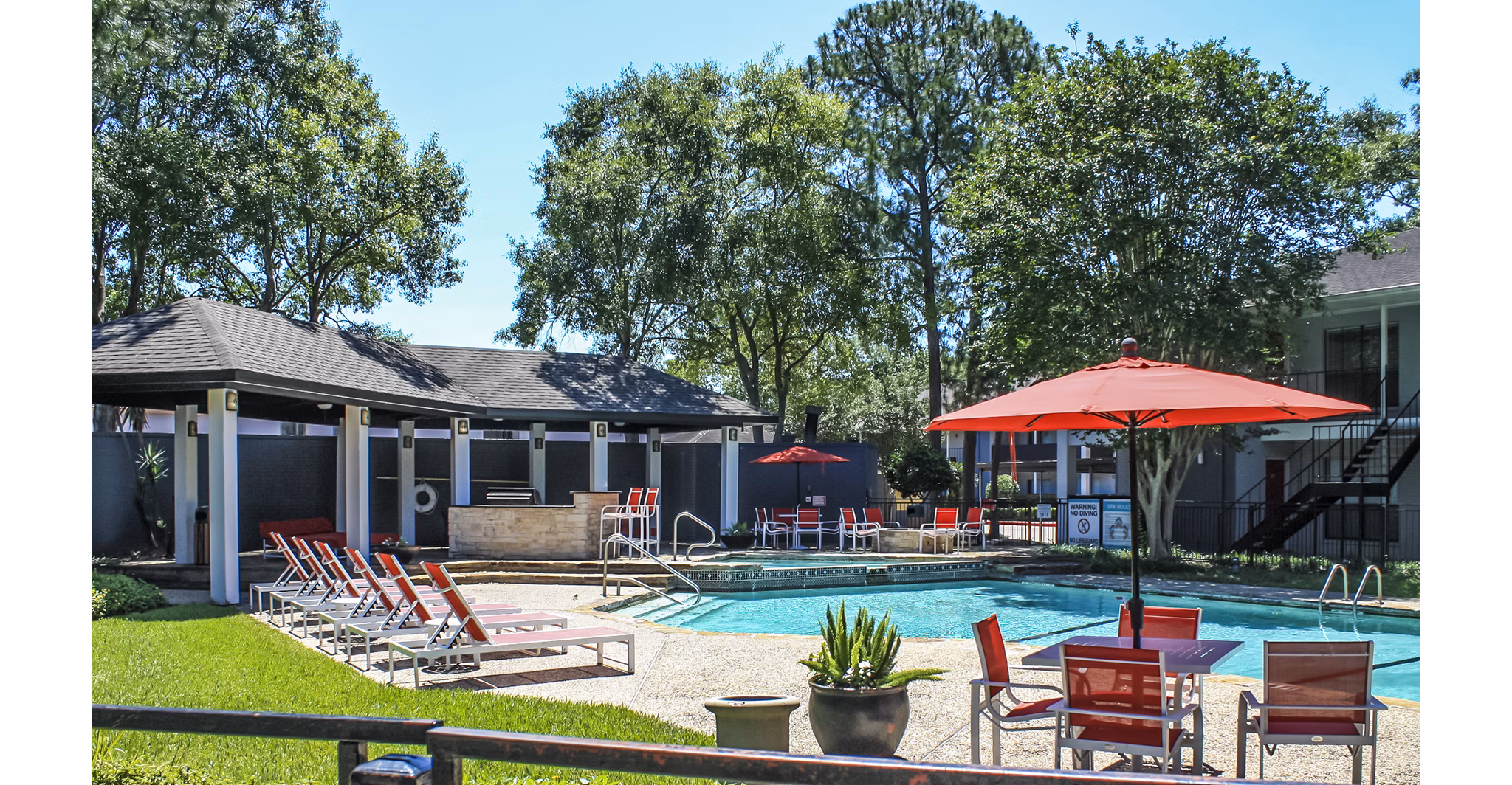 Pool with modern lounge chairs at 3 Corners West Apartments, a luxury residential community