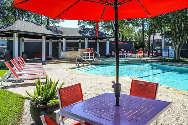 Refreshing pool with poolside loungers at 3 Corners West Apartments